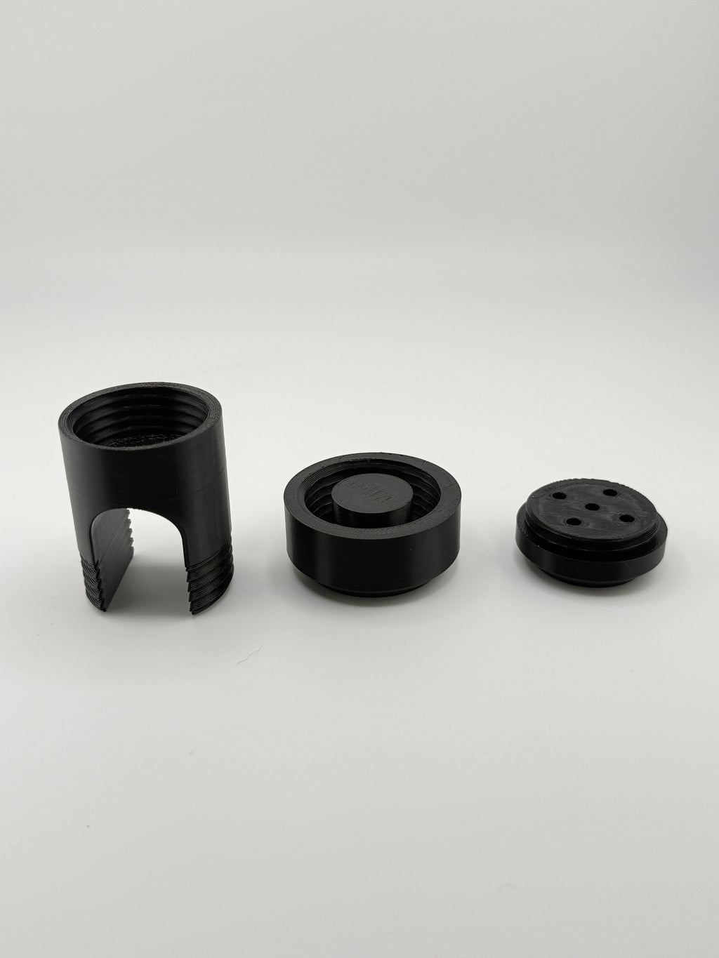 TrackMount three-piece kit: perforated cap, main body, and main cap in black PETG