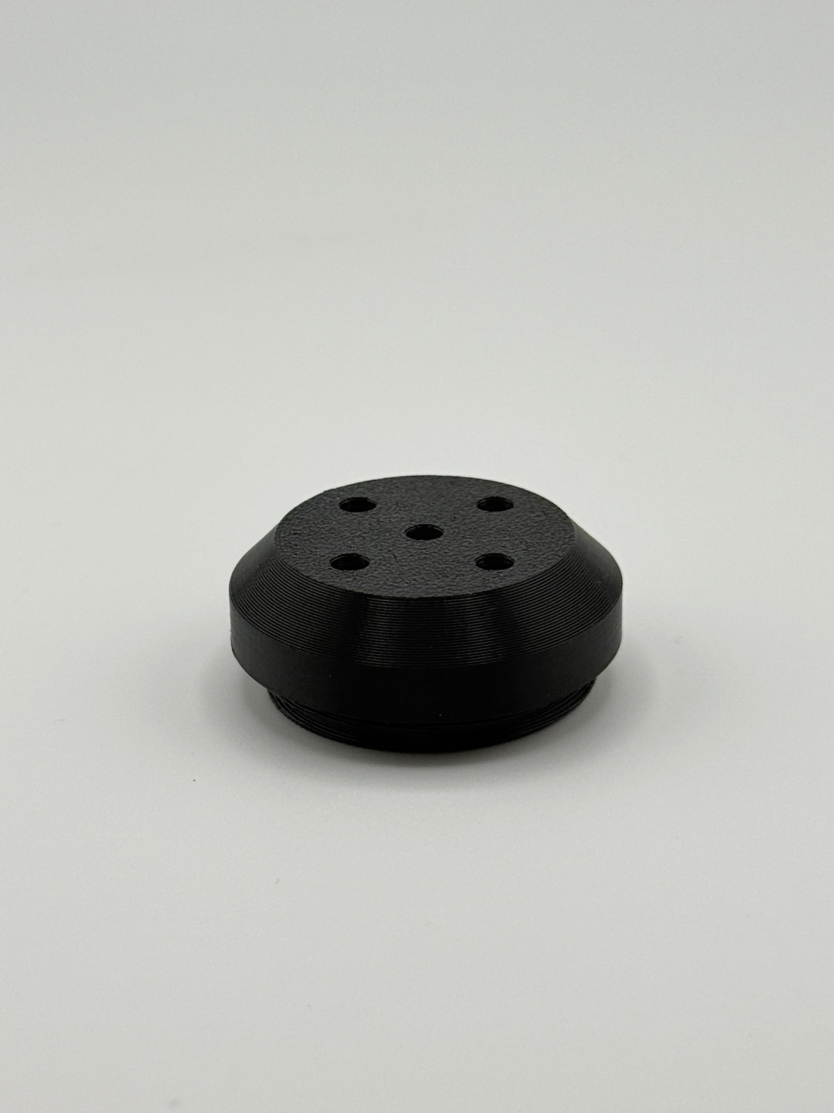 TrackMount perforated cap with five holes that let an AirTag chime ring through