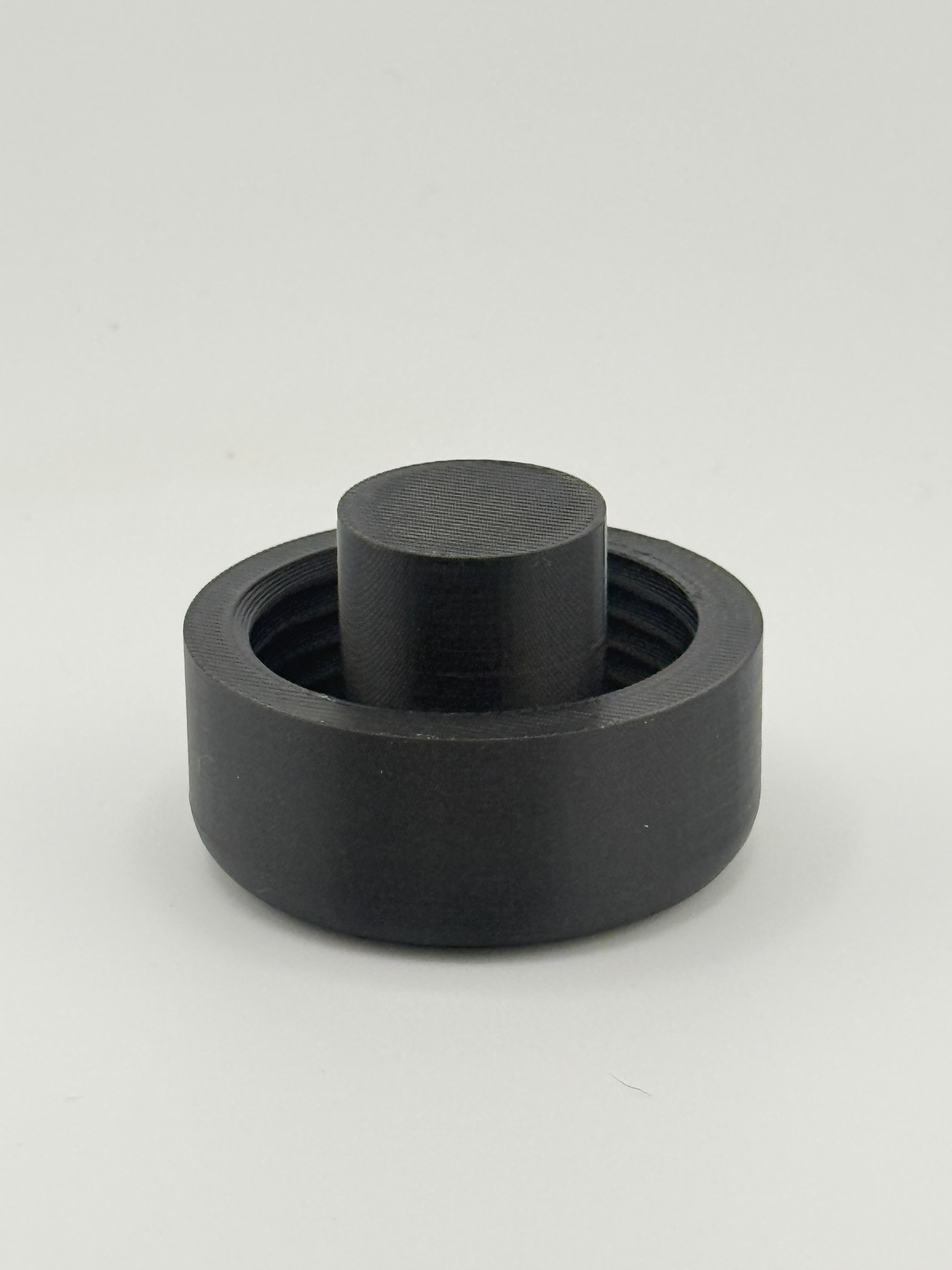 Single black TrackMount extended cap with the tall protruding stop rib used for securing to thinner white canes