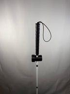 Black TrackMount mounted on a thin white cane shaft below the textured grip and wrist strap