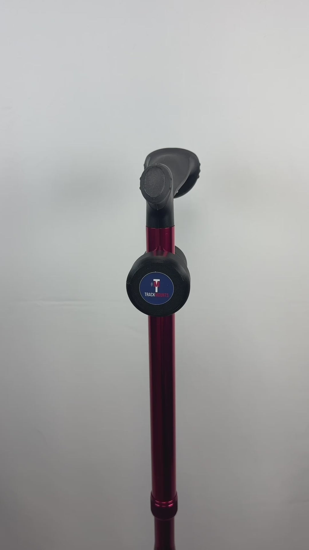 Video of a TrackMount mounted on a red walking cane, the cane is revolving 360 degrees displaying the TrackMounts.