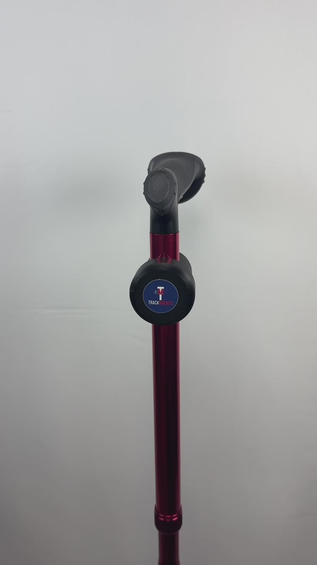 Video of a TrackMount mounted on a red walking cane, the cane is revolving 360 degrees displaying the TrackMounts.