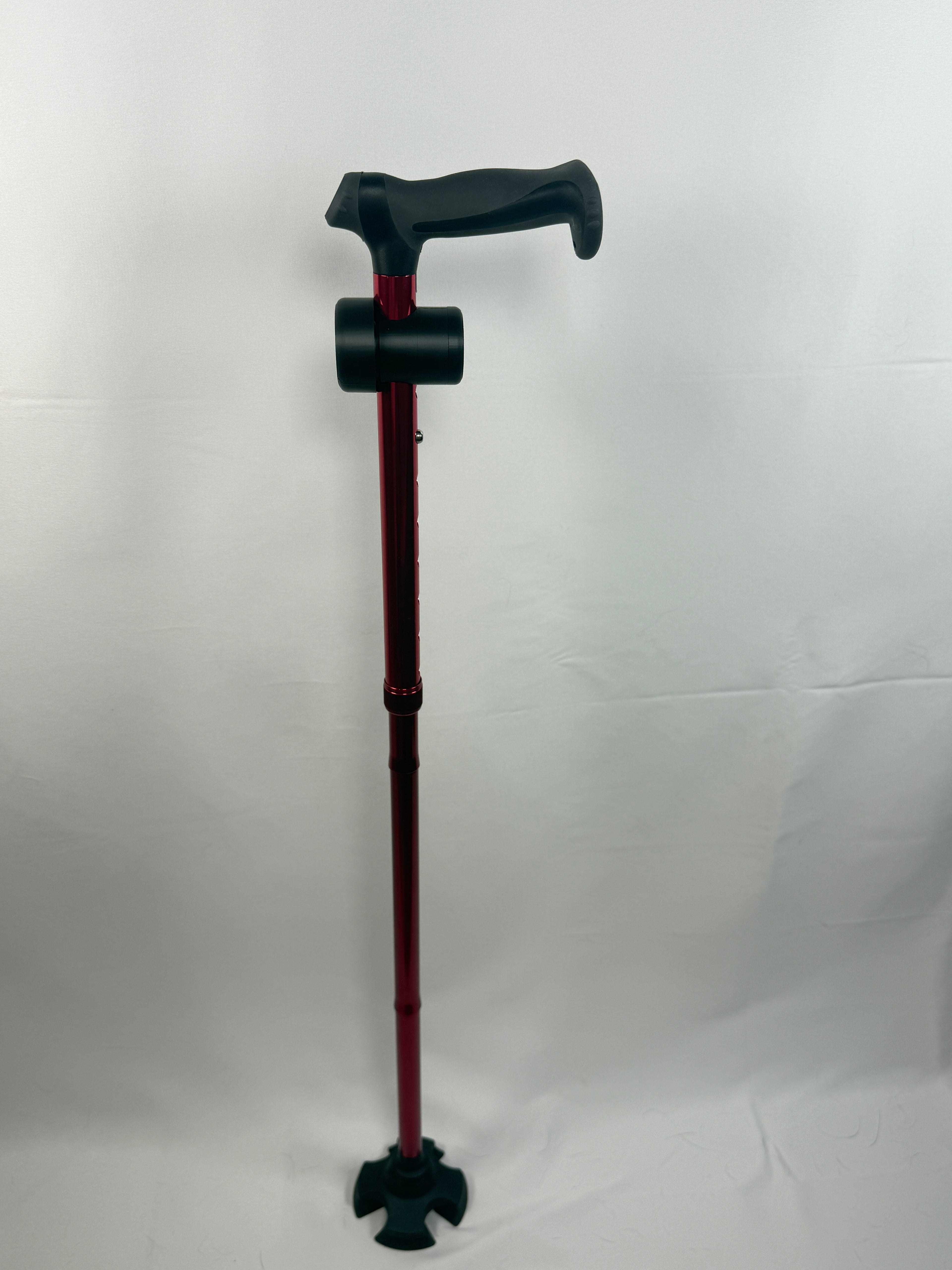 Full red walking cane standing upright with a black TrackMount mounted just below the handle