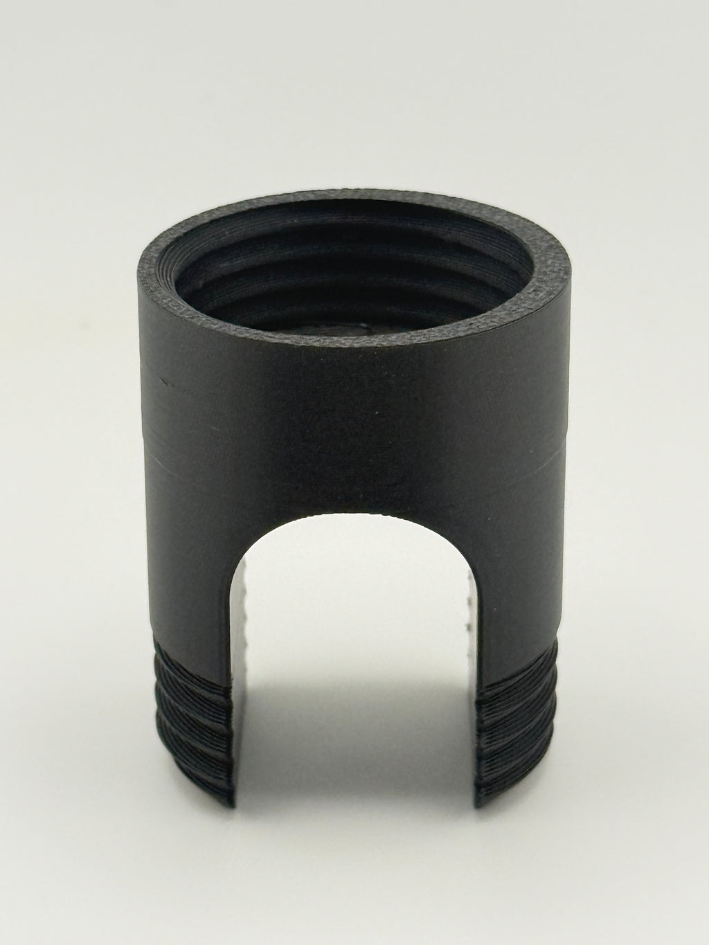 Black TrackMount main body showing the threaded tracker compartment on top and the U-shaped cane slot below