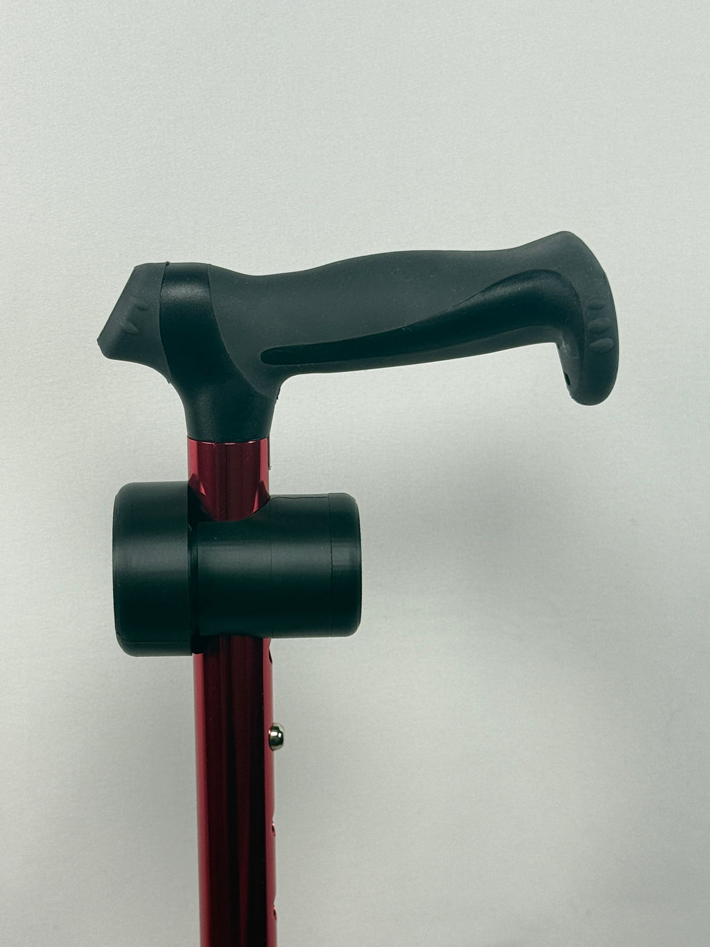 Black TrackMount attached to a red walking cane just below the ergonomic handle