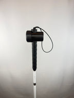 Black TrackMount with the main cap mounted on a thin white cane handle right below the wrist strap