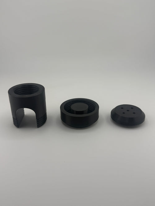 TrackMount XL three-part kit laid out: main body, main cap, and perforated cap in black PETG