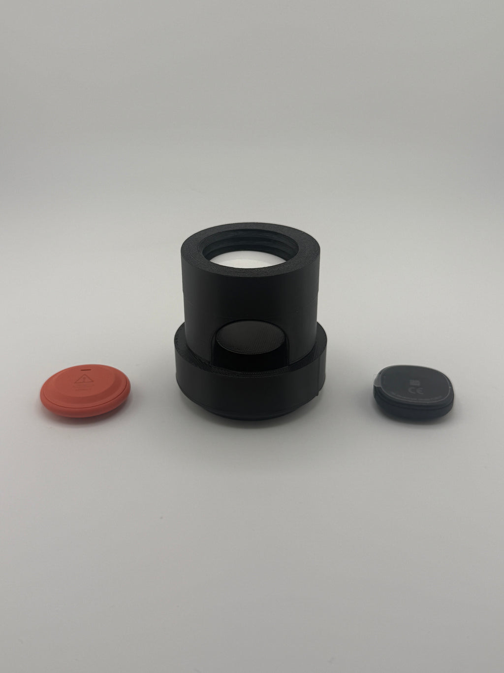 TrackMount XL holder shown with two Bluetooth trackers beside it, face down