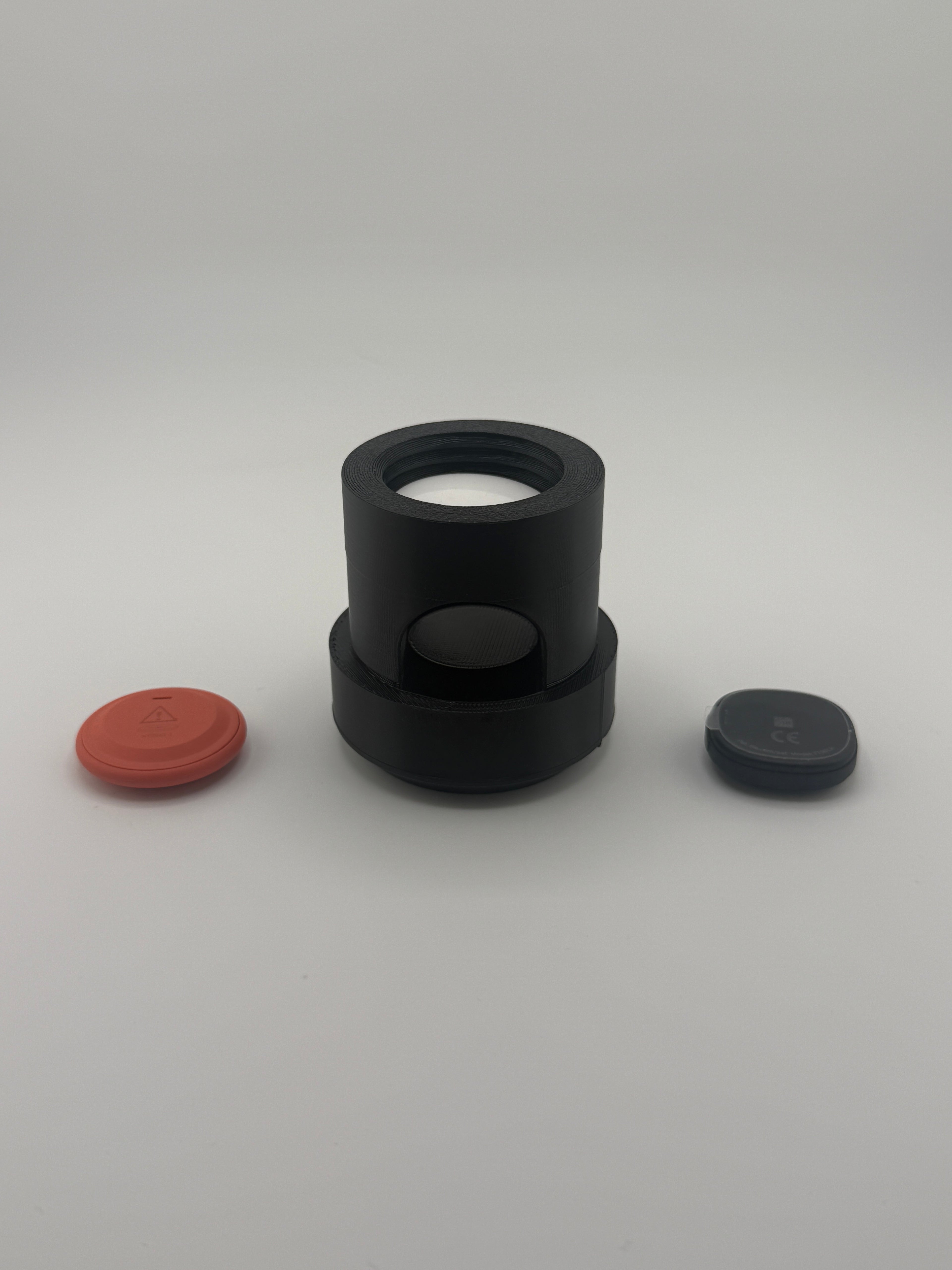 TrackMount XL holder shown with two Bluetooth trackers beside it, face down