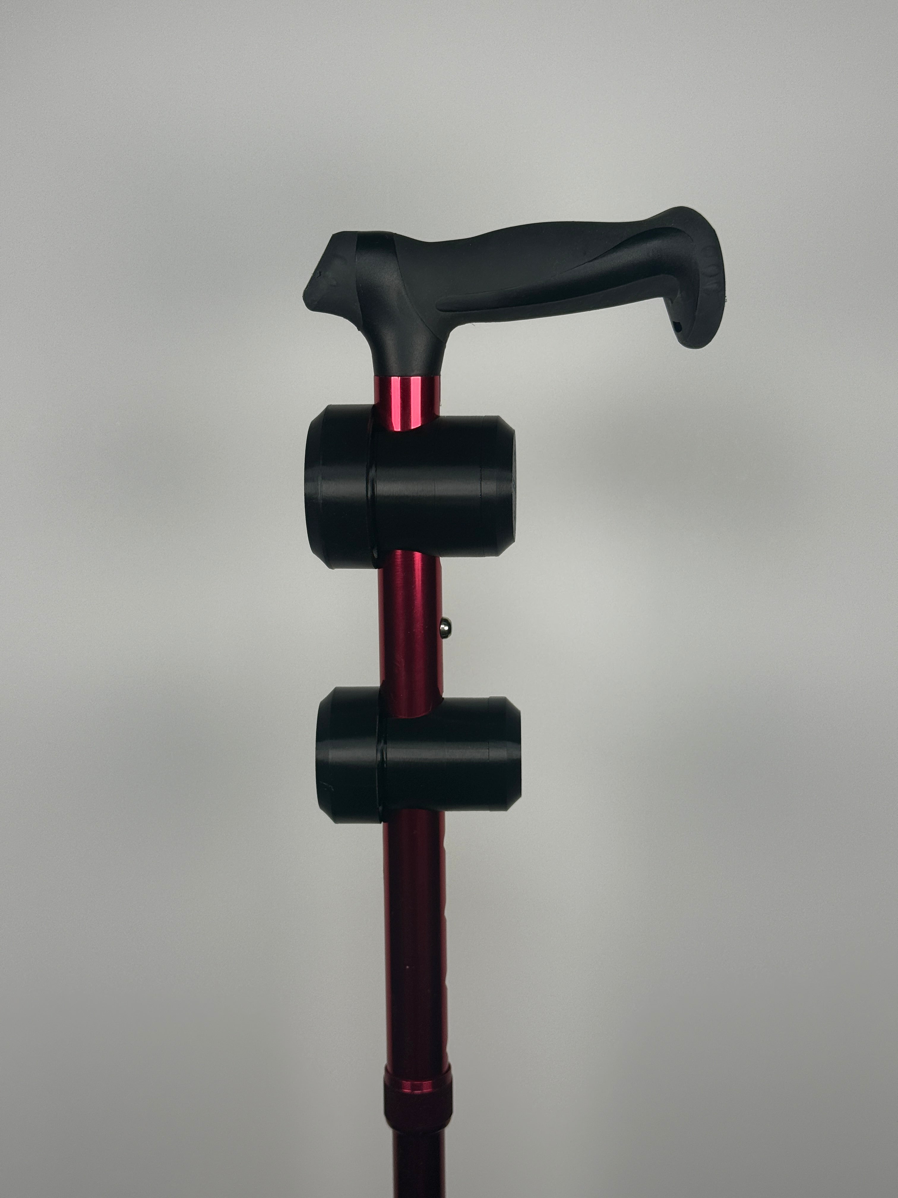 TrackMount XL and standard TrackMount mounted on the same aluminum cane, showing the size difference